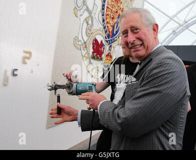 The Prince of Wales uses a 'tufting gun' to work on a wool carpet featuring the royal crest at a New Zealand Sheer Brilliance event in the Cloud in Auckland, New Zealand. Stock Photo