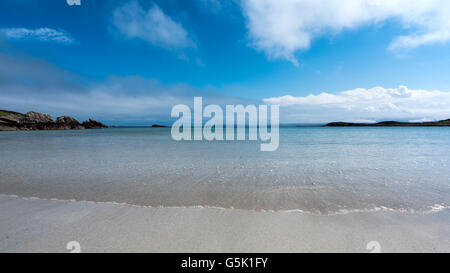 Crystal clear sea waters washing white shell sand beach at Mellon Udrigle Scotland on a hot sunny day. Stock Photo