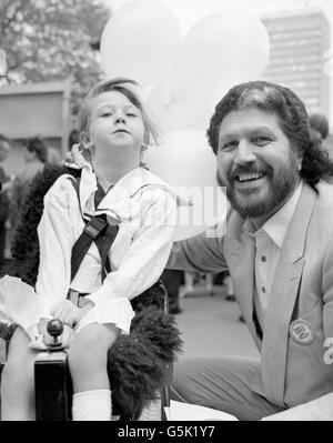 Six-year-old cerebral palsy sufferer Samantha Chambers, who lives in the Royal Mews at Buckingham Palace, shows Dave Lee Travis how she operates her 'turbo chair' at Speaker's Corner in Hyde Park. The DJ was there to launch National Speak Week, a campaign aimed at increasing public awareness of the problems faced by speech-impaired people. Stock Photo