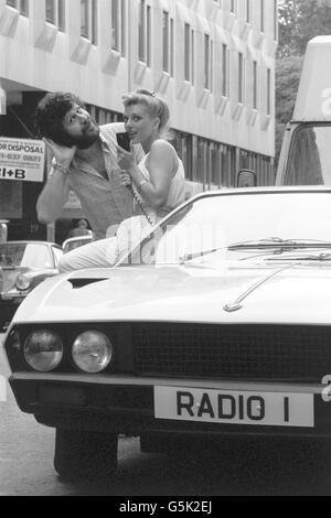 The First Citizen band radios in Britain were demonstrated by Fidelity Radio at the Eyeball Bistro Club in Princes Street, London, which is the first citizen band restaurant for CB enthusiasts. Outside the restaurant and tuned in are radio One DJ, and fellow CB fan, Dave Lee Travis and model Nicky Giles, 23, of London. Stock Photo