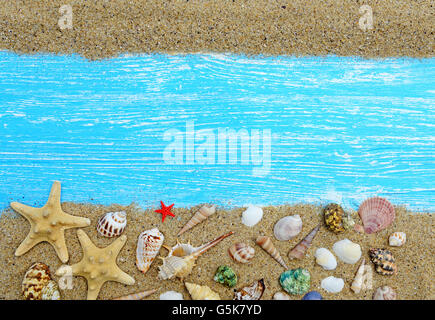 Sand, seashells and starfish on a wooden background Stock Photo