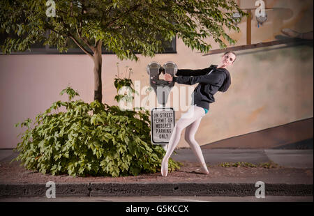 Caucasian ballet dancer posing with parking meter Stock Photo