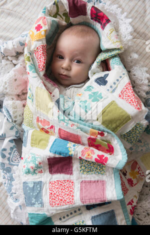 Caucasian baby wrapped in blanket Stock Photo