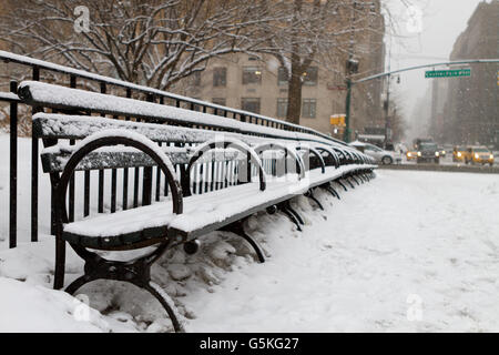 Central Park benches covered in snow during a New York City snowstorm Stock Photo