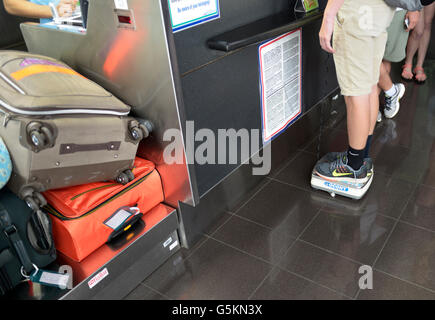 Weighing suitcase with digital scale for hand luggage on a flight Stock  Photo - Alamy