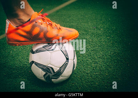 Photograph of a foot and a soccer ball on the grass Stock Photo