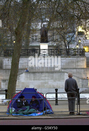 Spectators shelter under a tent Stock Photo