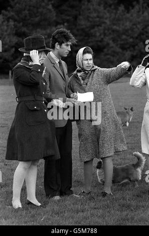 The Countess of Westmorland holds onto her hat, as the wind blows the hair of the Prince of Wales, in Windsor Great Park. With them is the Queen, taking an avid interest in the Royal Windsor Horse Show, in which the Duke of Edinburgh comptetes in the marathon section. Stock Photo