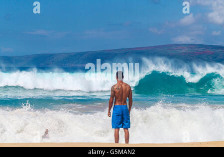 Man rides in wave as friend looks on at Big Beach in Makena State Park on Maui Stock Photo