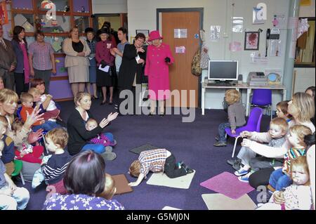 Her Royal Highness Queen Elizabeth II watches children sing at Hartcliffe & Withywood Ventures, The Gatehouse Centre in Hartcliffe, Bristol, where herself and the Duke of Edinburgh are touring the facilities, meeting staff and people who use the centre. The Queen also unveiled a plaque to commemorate her visit. Stock Photo