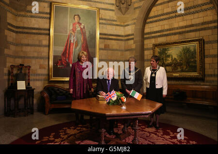 Irish President Michael D Higgins, signs the visitors book at Manchester Town Hall, as his wife Sabina (left) and the Lord Mayor of Manchester Elaine Boyes and Lady Mayoress Linda Geoghegan (far right) look on. Stock Photo