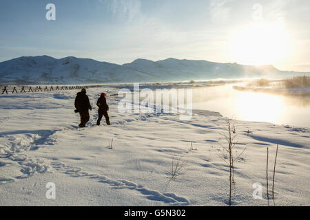 Caucasian couple walking in snowy landscape Stock Photo