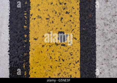 Asphalt highway texture with cracked white and yellow stripe Stock Photo