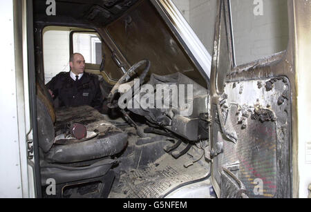 A police officers at Hayes police station examines a van used by robbers who attacked a BA security van in a secure airside cargo loading area near Heathrow Airport's Terminal 4, and who escaped with 4.6 million. * The vehicle was subsequently found abandoned and burning two miles away in a residential area in Feltham, west London. Government ministers responsible for aviation security have ordered a report on how thieves managed to gain access to the airport's restricted zone during a period of heightened security in the wake of events on September 11. Stock Photo