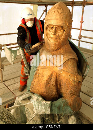 David Oakes from Mansell Construction sweeps dust from the statue of Robert the Bruce during mid restoration work on the weather-beaten statue of Robert the Bruce statue at the Battle of Bannockburn site, ahead of the 700th anniversary of the battle where Bruce is said to have defeated King Edward II's English army to secure an independent monarch for Scotland. Stock Photo