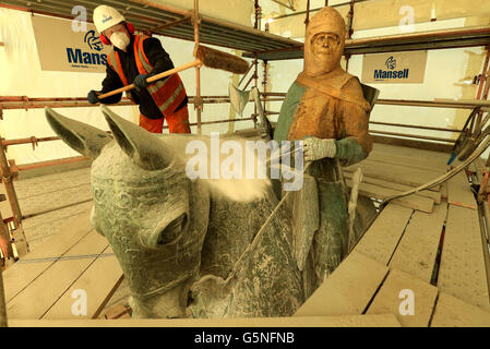 David Oakes from Mansell Construction sweeps dust from the statue of Robert the Bruce during mid restoration work on the weather-beaten statue of Robert the Bruce statue at the Battle of Bannockburn site, ahead of the 700th anniversary of the battle where Bruce is said to have defeated King Edward II's English army to secure an independent monarch for Scotland. Stock Photo