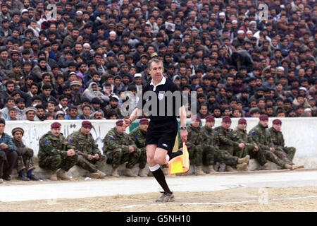 Assistant referee Andy Martin in action during a soccer match at the Olympic Stadium in Kabul, Afghanistan between ISAF (the International Security Assistance Force) and Kabul FC (in blue). The game was organised by the Football Association, the MoD and Barclaycard the new sponsors the Premiership. Lawrie McMenemy and former Tottenham Hotspurs player Gary Mabbutt have spent two days in the war torn country coaching both teams. The ISAF side includes soldiers from Great Britain, Italy, Germany and Holland and played in the Olympic Stadium more infamous for the executions held there by the Stock Photo