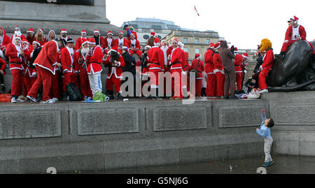 People dressed as Santa take part in the Santa flash mob at Trafalgar Square, London. Stock Photo