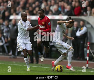 Soccer - Barclays Premier League - Swansea City v Manchester United - Liberty Stadium. Manchester United's Patrice Evra (centre) battles for the ball with Swansea City's Dwight Tiendalli (left) and Chico (right) Stock Photo