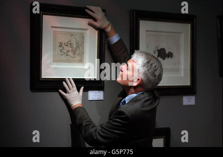 Fine Art and Antiques Consultant Duncan Phillips hangs a never before seen original artwork pencil drawing from Walt Disney's 'Snow White and the Seven Dwarfs' movie from 1937 at the Tatton Park antiques and fine art fair at Tatton Park in Knutsford, Cheshire. Stock Photo