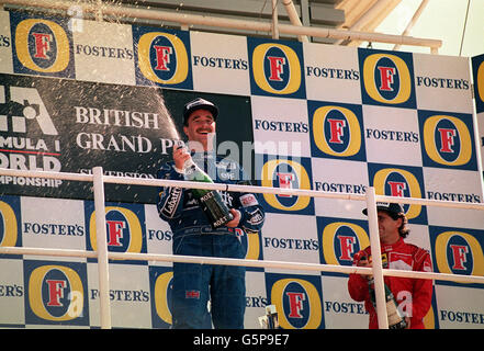 14th July - On this day in 1991 British F1 driver Nigel Mansell won the British Grand Prix at Silverstone. Nigel Mansell stands on the rostrum after winning the Fosters British Grand Prix at Silverstone. Stock Photo