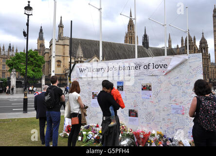 London, UK. 22nd June, 2016. People write tribute message on a board for Jo Cox, the 41-year-old Member of Parliament fatally shot last week, in Parliament Square, London, June 22, 2016. © Stanislav Mundil/CTK Photo/Alamy Live News Stock Photo