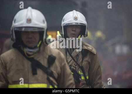 Hong Kong, China. 23rd June, 2016. Firefighters work at a multi-storey industrial building in East Kowloon area of Hong Kong, south China, June 23, 2016. The fire that broke out in an industrial building in Hong Kong was upgraded to No. 4 alarm on Tuesday night. A firefighter was killed and seven other firemen were injured when battling the blaze. Credit:  Lui Siu Wai/Xinhua/Alamy Live News Stock Photo