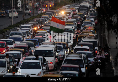 India Travel stock. A man riding a motorcycle carries an Indian flag through traffic on Marine Drive, Mumbai, India Stock Photo