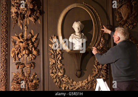 Restorer Graeme Dowling installs a newly carved wood frame to replace damaged 17th century works at the National Trust's Petworth House in West Sussex ahead of the property reopening to the public on March 23rd. * The Carved Room is covered with intricate works by Grinling Gibbons dating from the 1500's and 19th century details by Ritson who carved frames for paintings by Turner, a frequent visitor to Petworth. Stock Photo