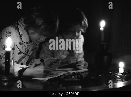 Colouring by candlelight for seven year old Tracy Caulkin (nearest camera) and her sister Jaqui, five, at their home in Woodburn Green as the nation faces another round of blackouts because of a work to rule by rebel power workers. Stock Photo