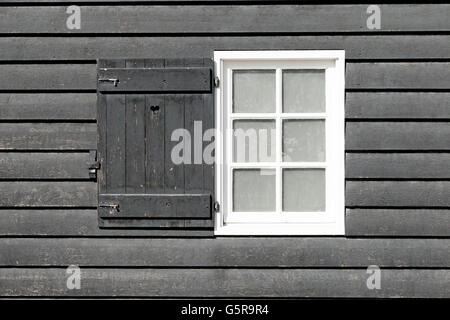 Black old wood window in country house. White window on black wooden wall. Window is open. Stock Photo
