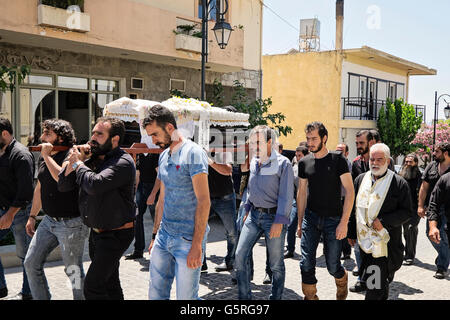 A funeral procession proceeds through the village of Anogia, on the island of Crete in Greece Stock Photo