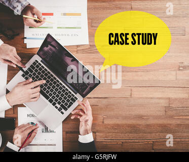 BUSINESS TEAM WORKING IN OFFICE WITH CASE STUDY SPEECH BUBBLE ON DESK Stock Photo