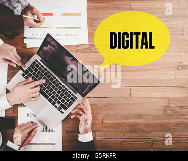 BUSINESS TEAM WORKING IN OFFICE WITH DIGITAL SPEECH BUBBLE ON DESK Stock Photo