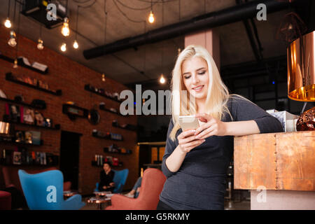 Young attractive female receptionist of beauty salon with smartphone Stock Photo