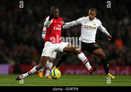 Soccer - FA Cup - Third Round Replay - Arsenal v Swansea - Emirates Stadium. Arsenal's Abou Diaby is challenged by Swansea's Wayne Routledge during the FA Cup Third Round Replay at the Emirates Stadium, London. Stock Photo