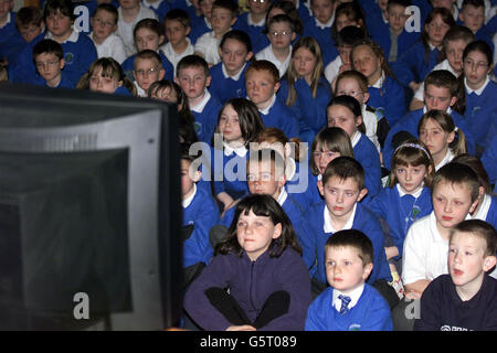 Children from Broughshane Primary school in Northern Ireland watch the Queen Mother's funeral on television .