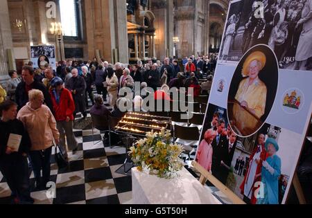 The congregation leave St Paul's Cathedral in central London past a collection of photographs of the the Queen Mother following a Service of Commemoration and Thanksgiving in her memory. Thousands of people have queued to pay their last respects at the coffin of the Queen Mother, who died on March 30, 2002 aged 101. After her funeral she will be interred at St George's Chapel in Windsor next to her late husband King George VI. Stock Photo