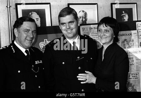 Proud moment for Metropolitan Police Commissioner Sir David McNee (left) as he introduces siege hero PC Trevor Lock to cameramen and reporters at New Scotland Yard. Just as proud is PC Lock's wife, Doreen, smiling as she hugs her courageous husband. Stock Photo