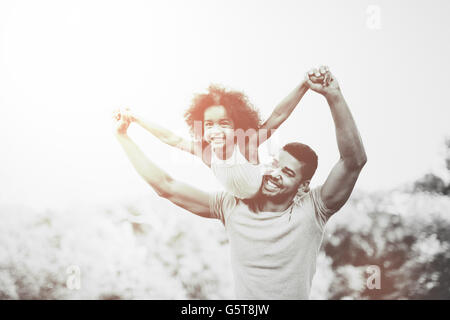 Father carrying daughter piggyback and being truly happy Stock Photo