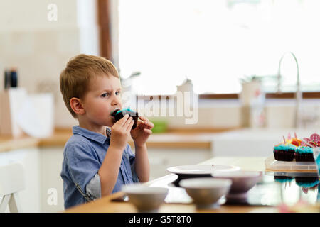 Cute child tasting cookies in kitchen Stock Photo