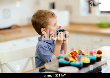 Cute child tasting cookies in kitchen Stock Photo