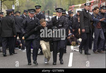 An activist from the Get Kissinger Group is led away by police whilst protesting against the arrival of Henry Kissinger, the former United States Secretary of State, who is to speak at an Institute of Directors meeting at the Royal Albert Hall in London. *Human rights campaigners and a group of leftwing Labour MPs have accused Dr Kissinger of aiding and abetting war crimes in Vietnam, Laos and Cambodia when he was in office. The theme of the conference, globalisation, was also expected to spark protests from anti-globalisation campaigners. Stock Photo