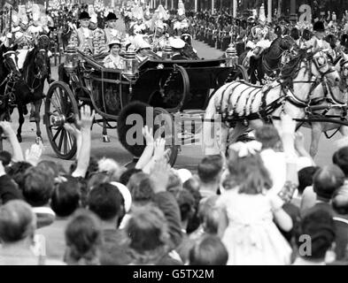 Through the troop-lined and crowded Mall, Queen Elizabeth II and her state visitor, the young King Feisal of Iraq drive in an open carriage to Buckingham Palace, London.