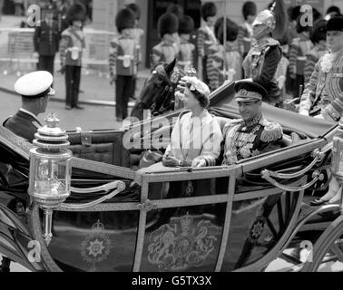 The Shah of Iran sits with Queen Elizabeth II in an open carriage as they drive with the Duke of Edinburgh to Buckingham Palace from Victoria Station, London. Stock Photo