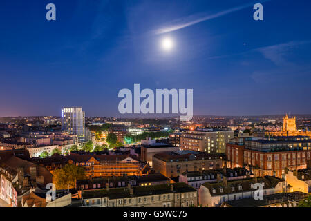 View over the City of Bristol skyline at night with the moon overhead, England. Stock Photo