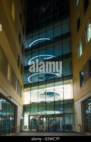 Glass fronted office block illuminated at night, Temple Quay, Bristol, England. Stock Photo