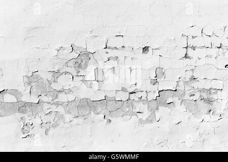 Background texture of old concrete wall with peeling layer of white paint Stock Photo