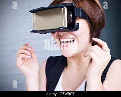 young asian woman experiencing virtual reality with head-mounted VR goggles. Stock Photo