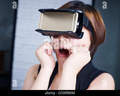young asian woman experiencing virtual reality with head-mounted VR goggles. Stock Photo